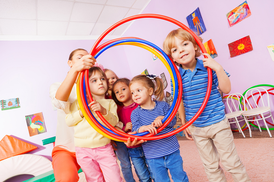 En flok legende børn ser gennem hulahop-ringe
