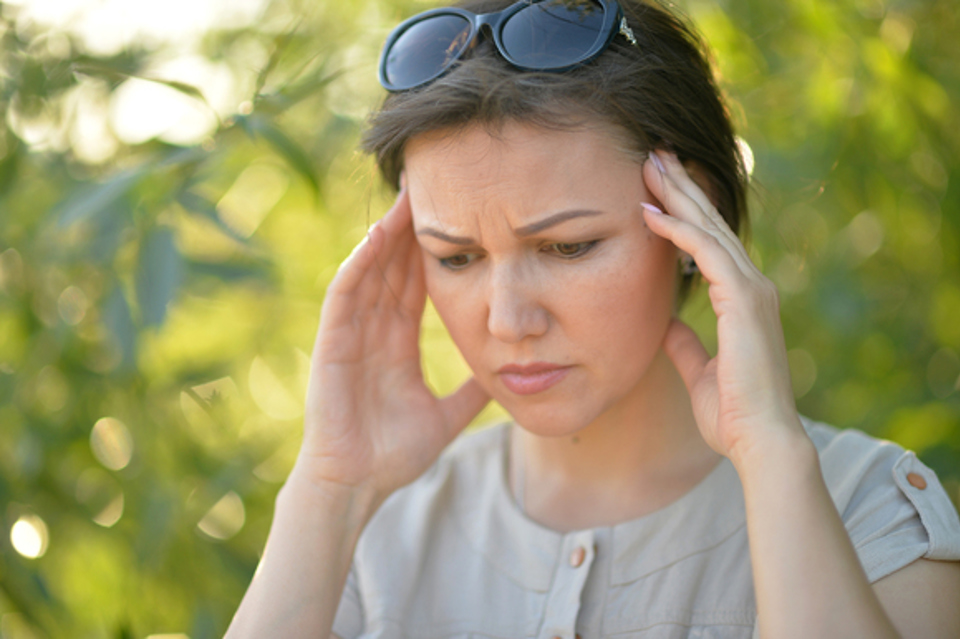 Kvinde tager sig til hovedet