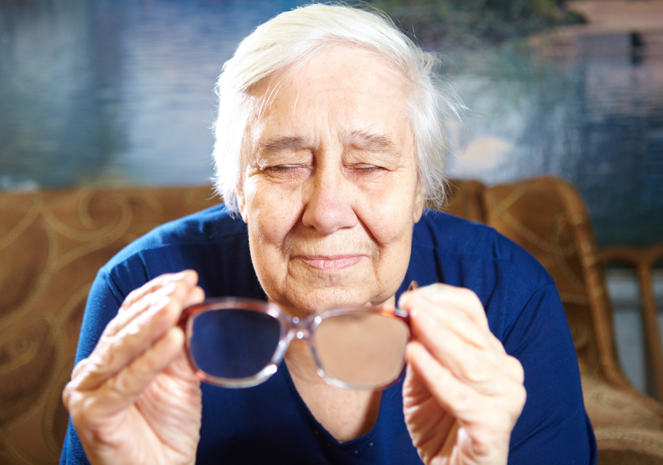 Ældre kvinde sidder med lukkede øjne og et par briller i hånden